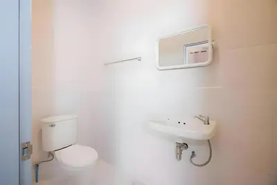 a white bathroom with a toilet and a sink at XX Mitr Inn Yaowarat China town -มิตร อินน์ เยาวราช in Bangkok