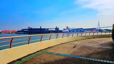 a bird walking on a sidewalk next to a bridge at River View Active 6 in Bangkok