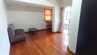 a living room with a chair and a table at Rachaprorob condo in Bangkok