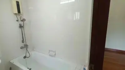 a white bathroom with a shower in a room at Rachaprorob condo in Bangkok