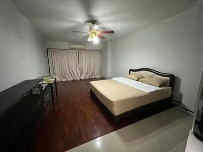 a bedroom with a bed and a ceiling fan at Srivara condo Rachada in Bangkok