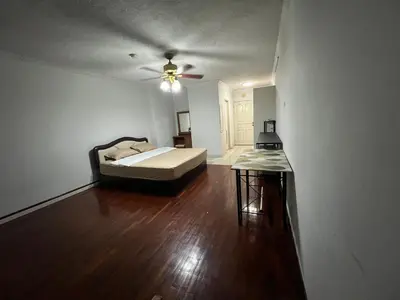 a bedroom with a bed and a table in it at Srivara condo Rachada in Bangkok