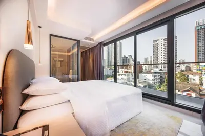 a bedroom with a white bed and large windows at Wanda Jin Residences The Ease Sierra Bangkok in Bangkok