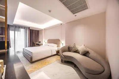 a hotel room with a bed and a couch at Wanda Jin Residences The Ease Sierra Bangkok in Bangkok