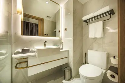 a bathroom with a toilet and a sink and a mirror at Wanda Jin Residences The Ease Sierra Bangkok in Bangkok