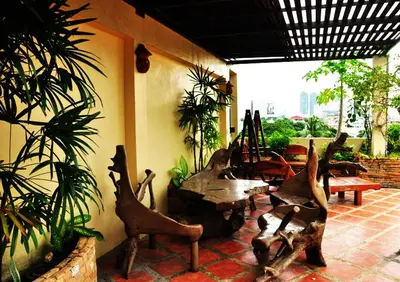 a patio with a table and chairs and plants at Sathorn View in Bangkok