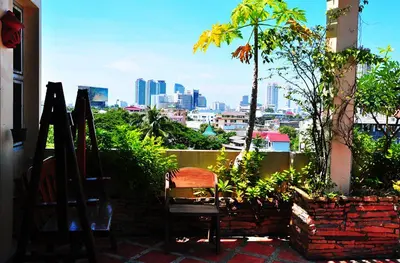 a chair sitting on a patio with a view of a city at Sathorn View in Bangkok