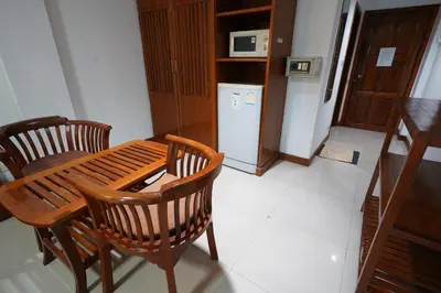 a kitchen with a wooden table and chairs and a refrigerator at Sathorn View in Bangkok