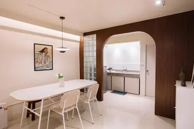 a kitchen and dining room with a white table and chairs at Liver Bird Ratchada in Bangkok