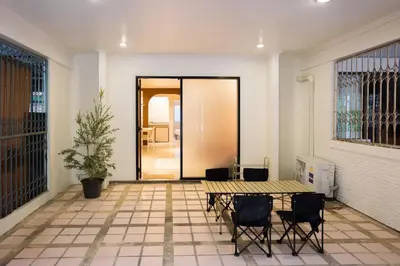 a patio with a table and chairs in front of a door at Liver Bird Ratchada in Bangkok