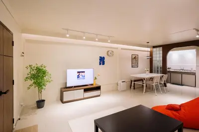 a living room with a red couch and a table at Liver Bird Ratchada in Bangkok