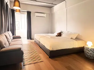 a bedroom with a bed with a dog sitting on it at Human Touch Room - Soulful Bangkok Hideout in Lat Krabang