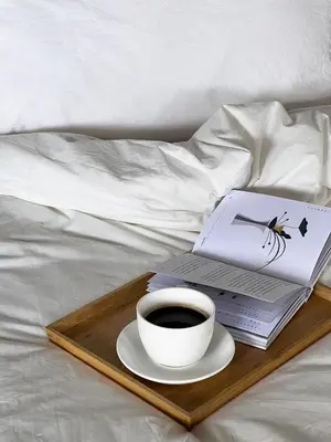 a tray with a cup of coffee and a laptop on a bed at Human Touch Room - Soulful Bangkok Hideout in Lat Krabang