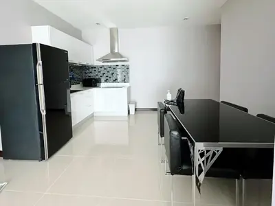 a kitchen with a black refrigerator and white cabinets at The Prime 11 Sukhumvit 11 2BR near BTS Nana in Bangkok