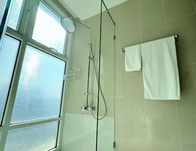 a bathroom with a shower with a glass door at The Prime 11 Sukhumvit 11 2BR near BTS Nana in Bangkok