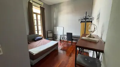 a bedroom with a bed and a desk and a table at Tarzan DZ Bangkok Luxurious Villa in Sathani Ban Hua Mak