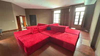 a large red couch in a living room at Tarzan DZ Bangkok Luxurious Villa in Sathani Ban Hua Mak