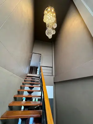 a staircase in a building with a chandelier at Tarzan DZ Bangkok Luxurious Villa in Sathani Ban Hua Mak