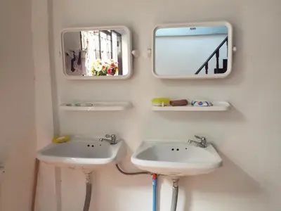 a bathroom with two sinks and two mirrors at Hostel 24 in Bangkok