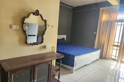 a small bedroom with a mirror and a bed at Baan Nara 15 in Bangkok
