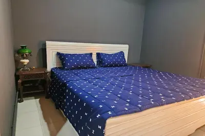 a bed with a blue comforter and two blue pillows at Baan Nara 15 in Bangkok