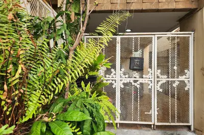 a white gate in a room with plants at Baan Nara 15 in Bangkok
