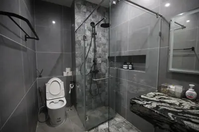 a bathroom with a shower with a toilet and a sink at Chic Ekkamai Escape Near BTS, Dining & Nightlife in Bangkok