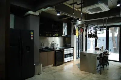 a kitchen with a counter and a table in it at Chic Ekkamai Escape Near BTS, Dining & Nightlife in Bangkok