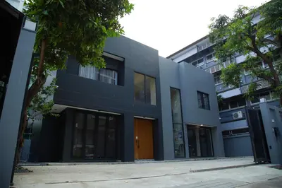 a blue building with a orange door in front at Chic Ekkamai Escape Near BTS, Dining & Nightlife in Bangkok