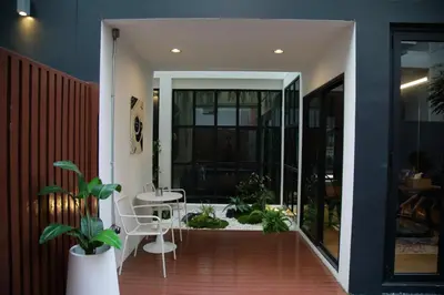 a hallway with a patio with a table and chairs at Chic Ekkamai Escape Near BTS, Dining & Nightlife in Bangkok