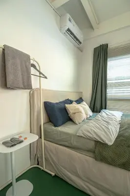 a small room with a bed with a window at nap in a blue moon in Bangkok