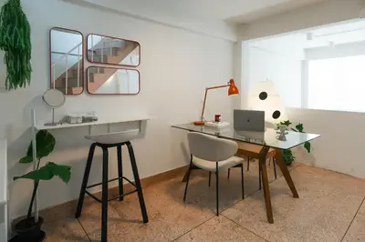 a desk with a laptop and chairs in a room at nap in a blue moon in Bangkok