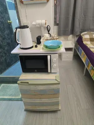 a microwave sitting on top of books in a room at 103 Olan Place Peaceful Apartment near SkyTrain and free Wi-Fi in Bangkok
