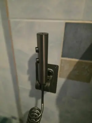 a metal toilet paper dispenser on a wall at 103 Olan Place Peaceful Apartment near SkyTrain and free Wi-Fi in Bangkok
