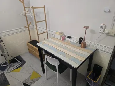 a wooden table and a chair in a room at 103 Olan Place Peaceful Apartment near SkyTrain and free Wi-Fi in Bangkok