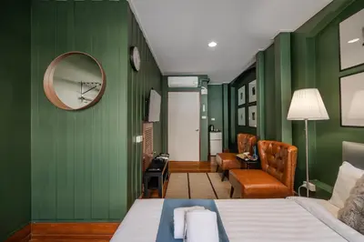 a bedroom with green walls and a bed and a mirror at Arun Sa Wad - Yaowarat 27 in Bangkok