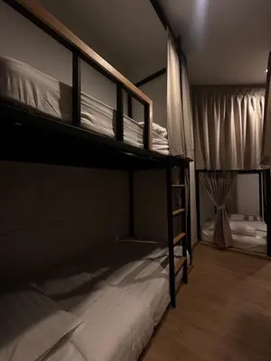 a bedroom with two bunk beds with white sheets at Around Ari Hostel in Bangkok