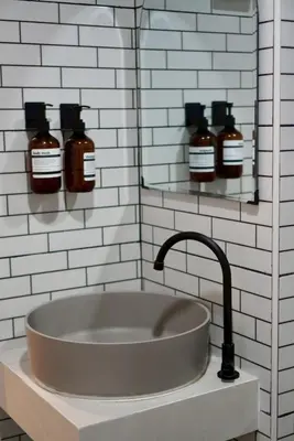 a bathroom with a sink and two bottles of honey at Around Ari Hostel in Bangkok