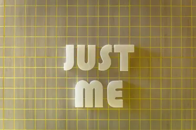a sign that says just me next to a wall at jasminespace in Khlong San