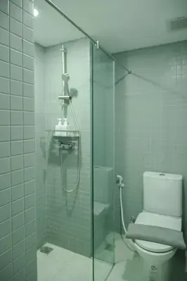a bathroom with a toilet and a glass shower at jasminespace in Khlong San