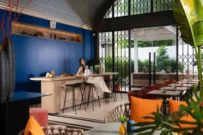 a woman sitting at a bar in a restaurant at Hotel Bangkokian in Bangkok