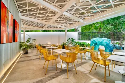 a restaurant with tables and chairs and plants at Hotel Bangkokian in Bangkok