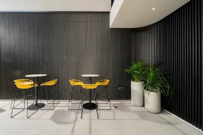 two yellow chairs and two plants in a room at Hotel Bangkokian in Bangkok