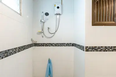 a shower in a bathroom with a blue towel at Surawong Condominium in Bangkok