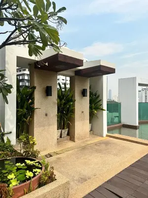 a building with a balcony with plants on it at Spacious Sukhumvit Condo near EmQuartier in Bangkok