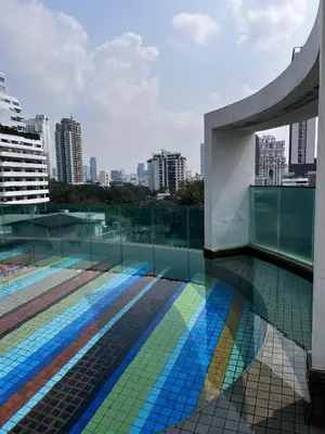 a building with a pool with a view of a city at Spacious Sukhumvit Condo near EmQuartier in Bangkok