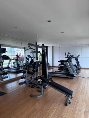 a gym with several treadmills and elliptical machines at Spacious Sukhumvit Condo near EmQuartier in Bangkok