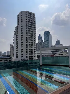 a swimming pool with a city skyline in the background at Spacious Sukhumvit Condo near EmQuartier in Bangkok