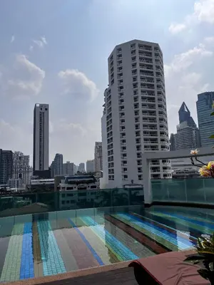 a swimming pool with a city skyline in the background at Spacious Sukhumvit Condo near EmQuartier in Bangkok