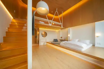 a bedroom with a bed and stairs in a room at Vaeh Viean Silom in Bangkok